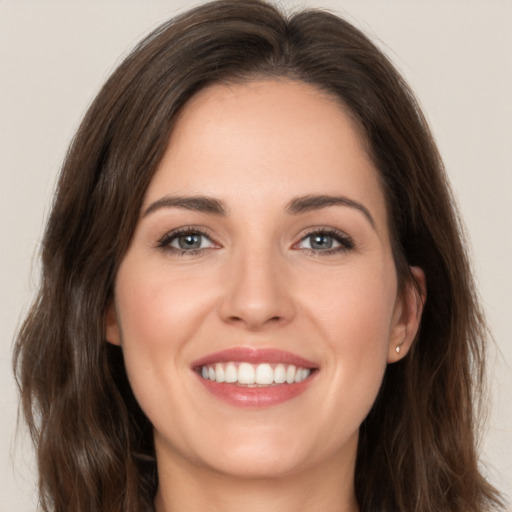 Joyful white young-adult female with long  brown hair and brown eyes