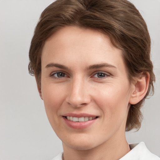 Joyful white young-adult female with medium  brown hair and grey eyes