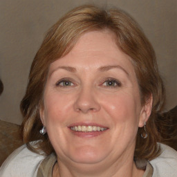 Joyful white adult female with medium  brown hair and blue eyes