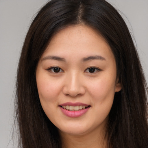 Joyful asian young-adult female with long  brown hair and brown eyes