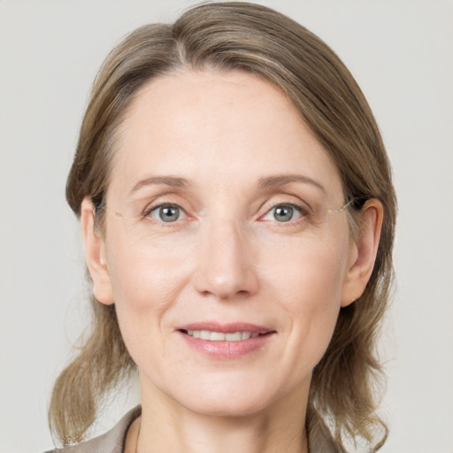 Joyful white adult female with medium  brown hair and grey eyes