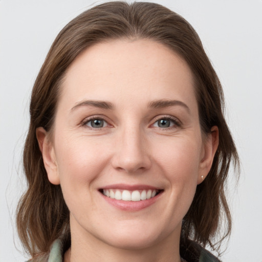 Joyful white young-adult female with medium  brown hair and grey eyes