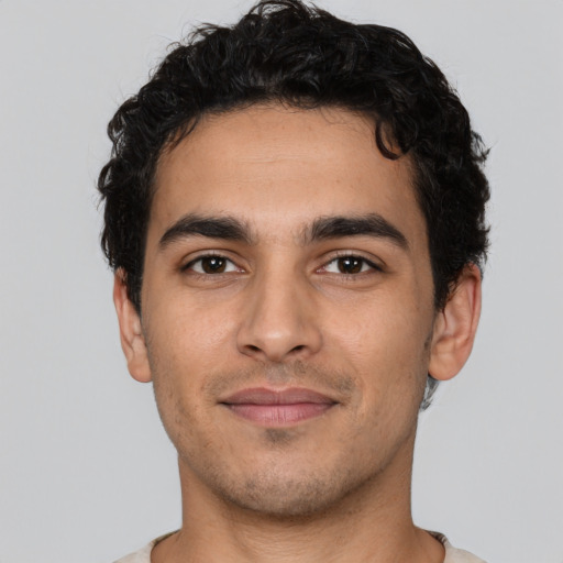 Joyful latino young-adult male with short  brown hair and brown eyes