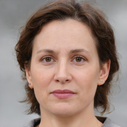 Joyful white adult female with medium  brown hair and grey eyes