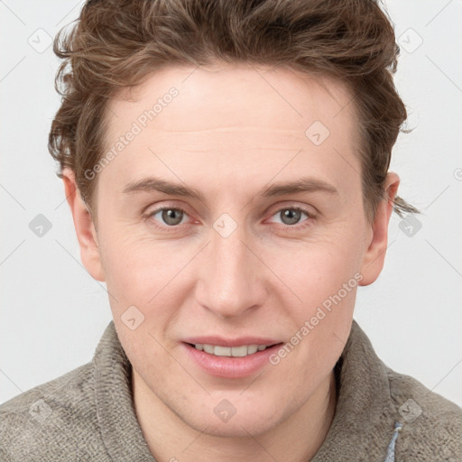 Joyful white young-adult male with short  brown hair and blue eyes