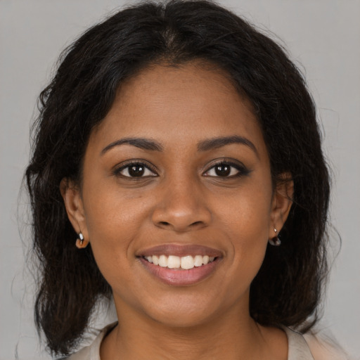 Joyful black young-adult female with medium  brown hair and brown eyes