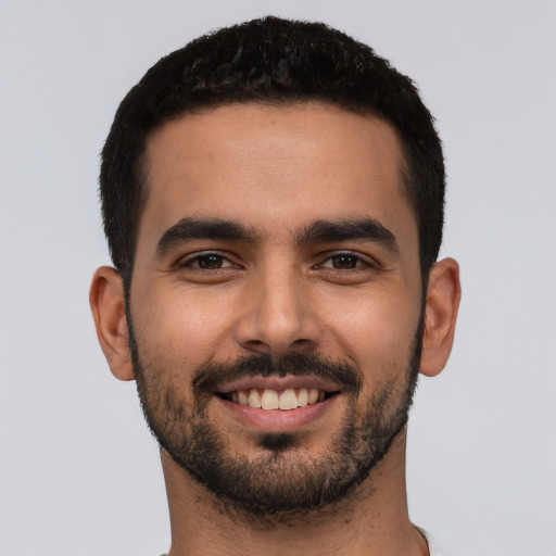 Joyful latino young-adult male with short  black hair and brown eyes