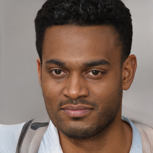 Joyful black young-adult male with short  brown hair and brown eyes
