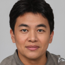 Joyful asian young-adult male with short  brown hair and brown eyes