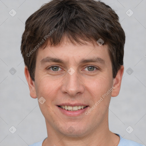 Joyful white young-adult male with short  brown hair and grey eyes