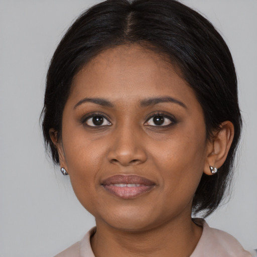 Joyful black young-adult female with medium  brown hair and brown eyes