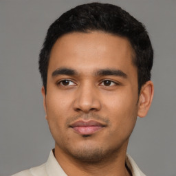 Joyful latino young-adult male with short  black hair and brown eyes