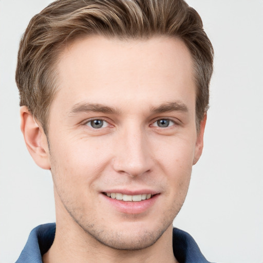 Joyful white young-adult male with short  brown hair and grey eyes