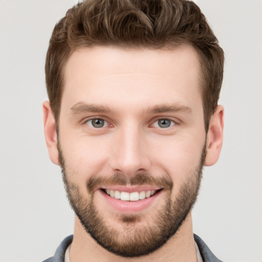 Joyful white young-adult male with short  brown hair and grey eyes