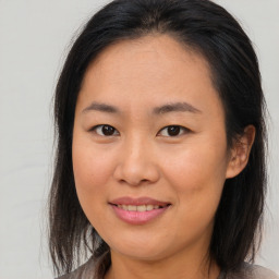 Joyful asian young-adult female with medium  brown hair and brown eyes