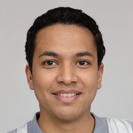 Joyful latino young-adult male with short  black hair and brown eyes