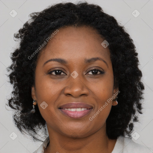 Joyful black young-adult female with long  brown hair and brown eyes