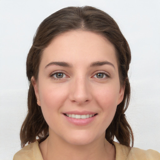 Joyful white young-adult female with medium  brown hair and grey eyes