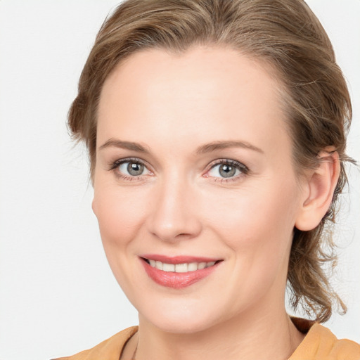 Joyful white young-adult female with medium  brown hair and blue eyes