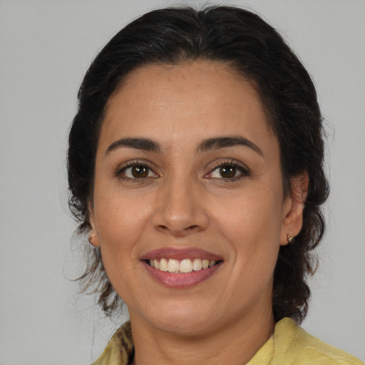 Joyful latino adult female with medium  brown hair and brown eyes