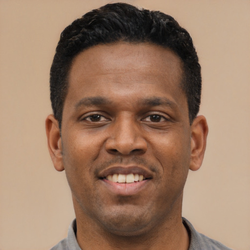 Joyful latino young-adult male with short  black hair and brown eyes