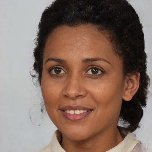 Joyful black young-adult female with medium  brown hair and brown eyes