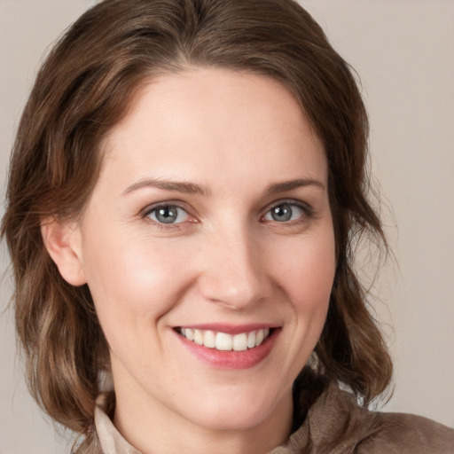 Joyful white young-adult female with medium  brown hair and grey eyes