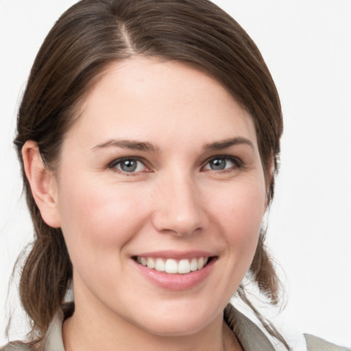 Joyful white young-adult female with medium  brown hair and grey eyes