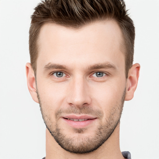 Joyful white young-adult male with short  brown hair and grey eyes