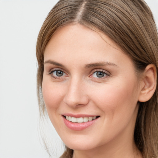 Joyful white young-adult female with long  brown hair and grey eyes