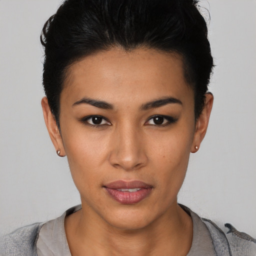 Joyful latino young-adult female with short  black hair and brown eyes