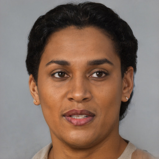 Joyful black young-adult female with short  black hair and brown eyes