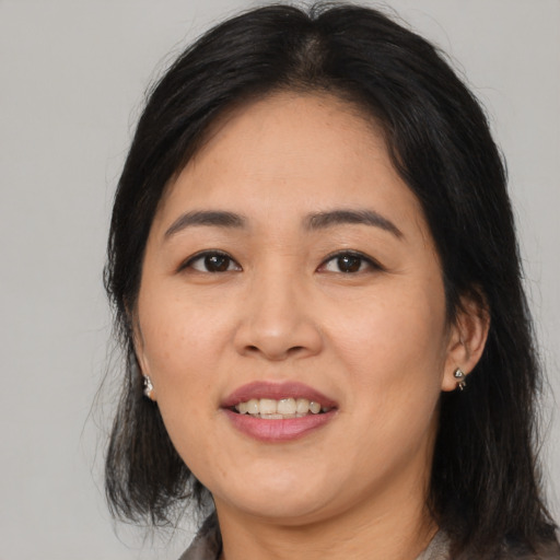 Joyful asian adult female with medium  black hair and brown eyes