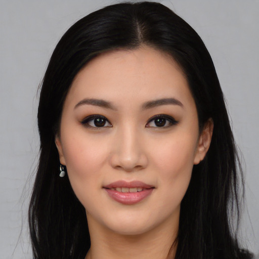 Joyful asian young-adult female with long  black hair and brown eyes