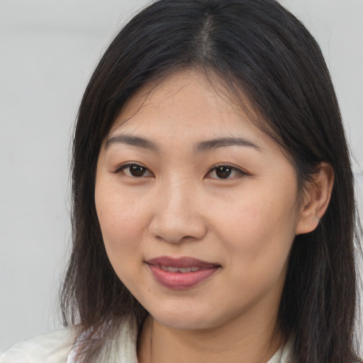 Joyful asian young-adult female with long  brown hair and brown eyes