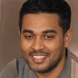 Joyful black young-adult male with short  black hair and brown eyes