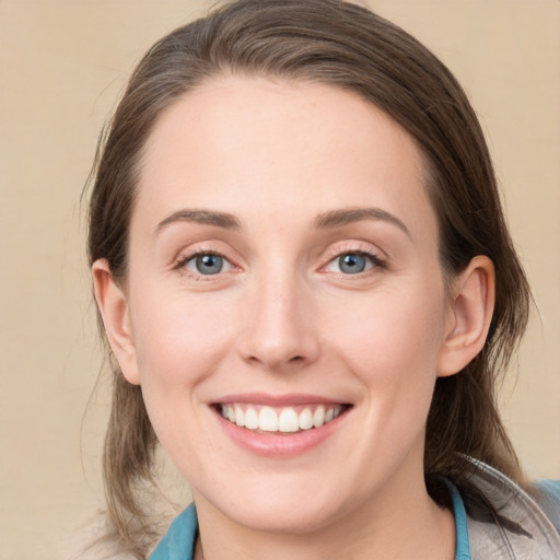 Joyful white young-adult female with medium  brown hair and blue eyes