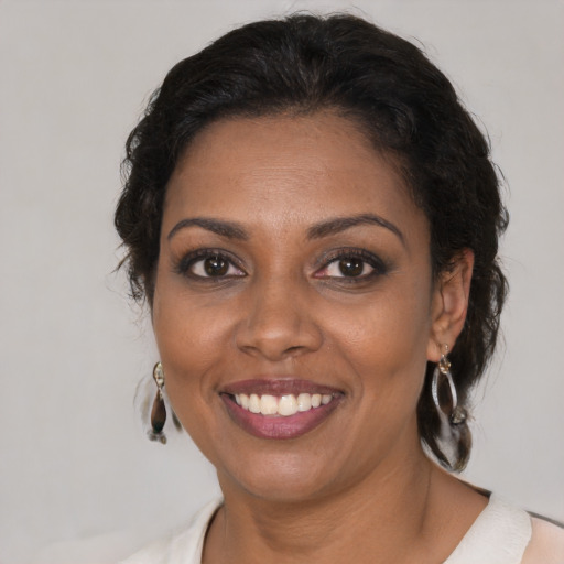 Joyful black adult female with medium  brown hair and brown eyes