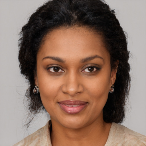 Joyful black young-adult female with long  brown hair and brown eyes
