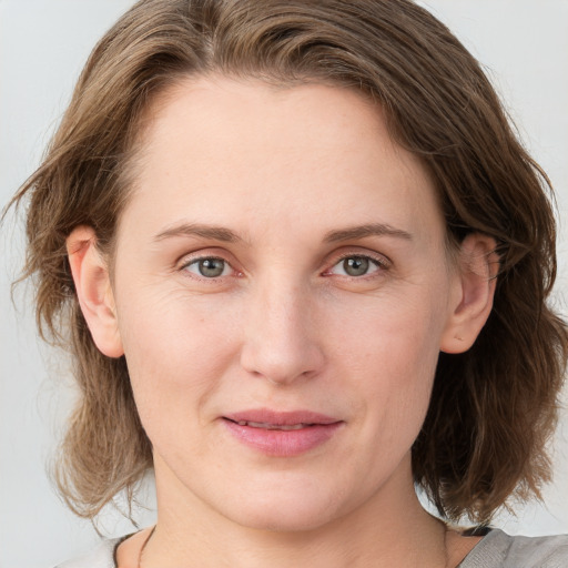 Joyful white young-adult female with medium  brown hair and blue eyes