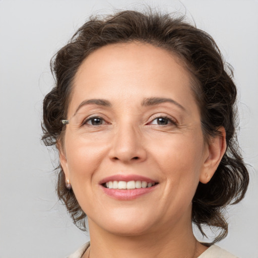 Joyful white adult female with medium  brown hair and brown eyes