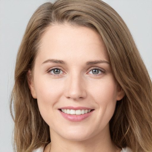 Joyful white young-adult female with long  brown hair and grey eyes