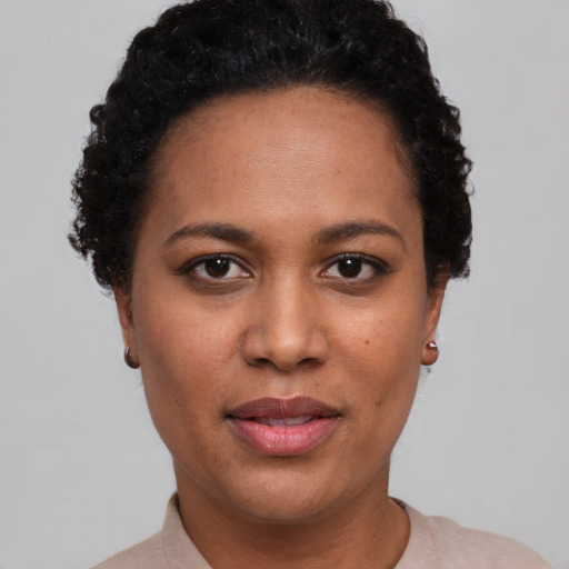 Joyful black young-adult female with short  brown hair and brown eyes