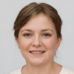 Joyful white young-adult female with medium  brown hair and grey eyes