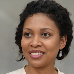 Joyful black adult female with medium  brown hair and brown eyes