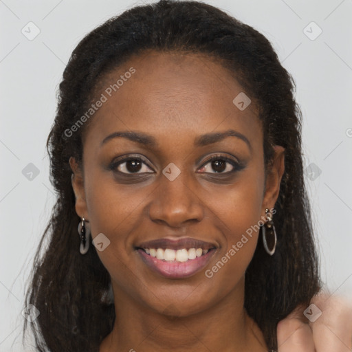 Joyful black young-adult female with long  brown hair and brown eyes