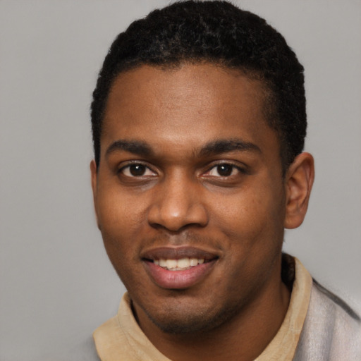 Joyful black young-adult male with short  black hair and brown eyes