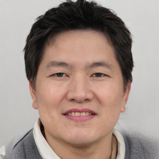 Joyful asian young-adult male with short  brown hair and brown eyes