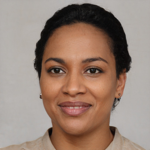 Joyful black young-adult female with short  black hair and brown eyes