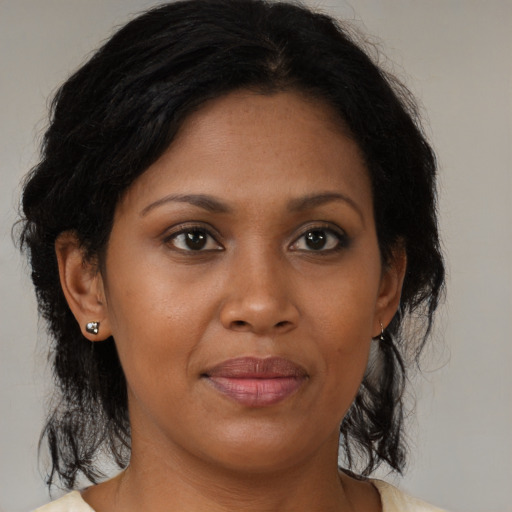 Joyful black adult female with medium  brown hair and brown eyes
